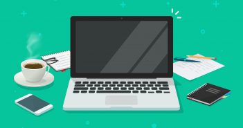Laptop-First Strategy Rolls Out Laptop surrounded by coffee cup, phone, notebooks
